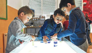 Un grupo de alumnos del colegio público ilicitano Princesa de Asturias se divierte en el taller de luz. 